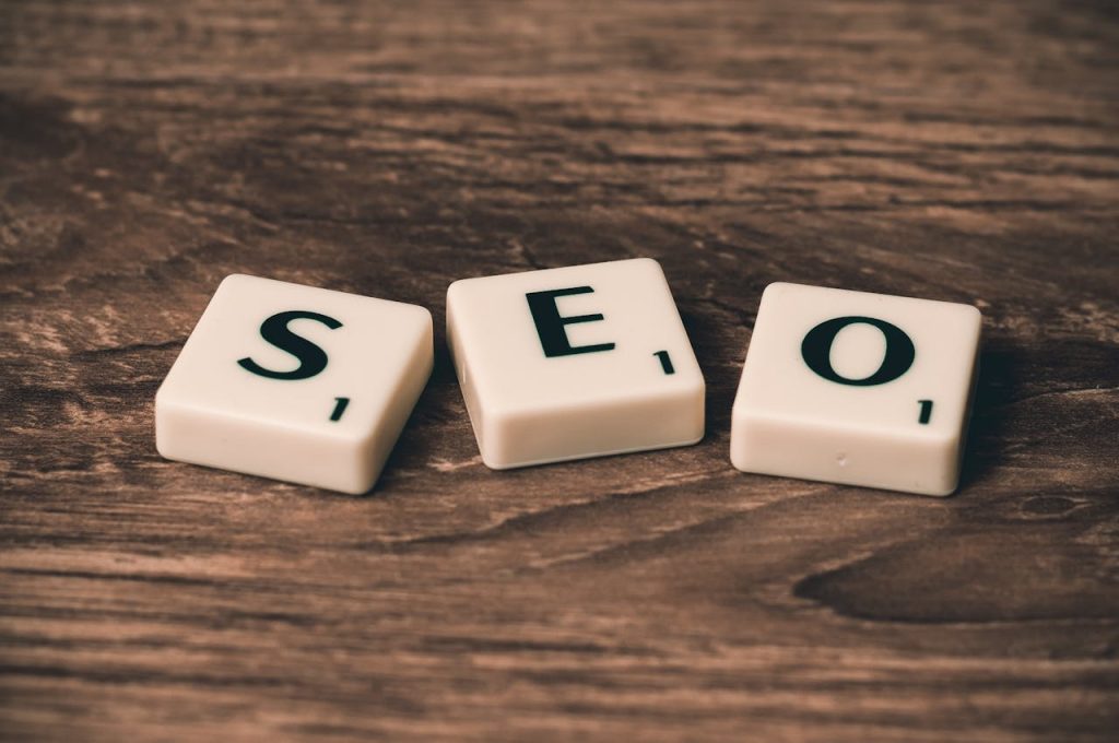 Home 5 Scrabble tiles spelling SEO on a wooden surface. Ideal for digital marketing themes.